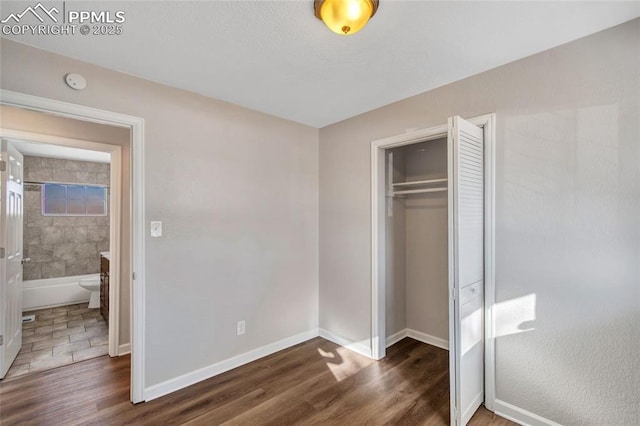 bedroom with dark wood-type flooring and a closet