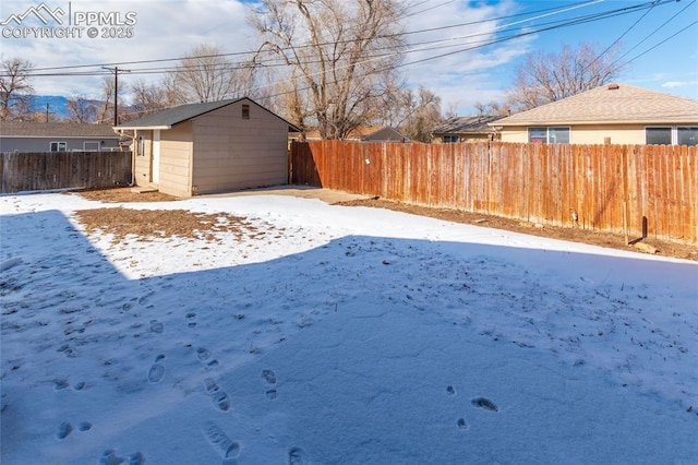 yard covered in snow with a storage unit