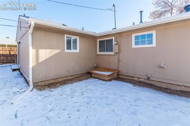 view of snow covered rear of property