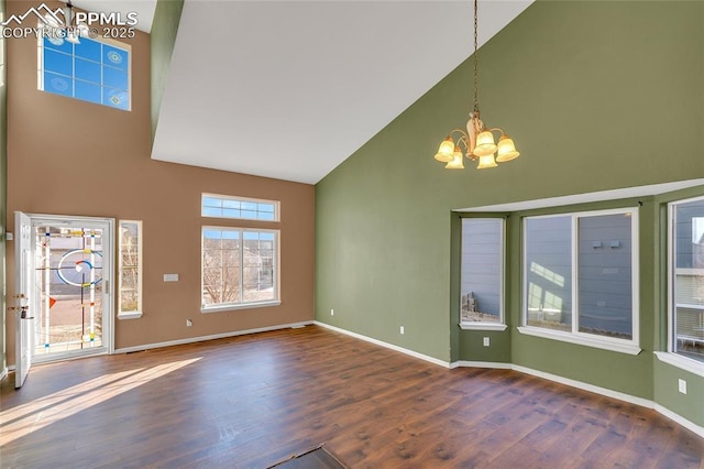 interior space featuring dark hardwood / wood-style flooring, high vaulted ceiling, and an inviting chandelier