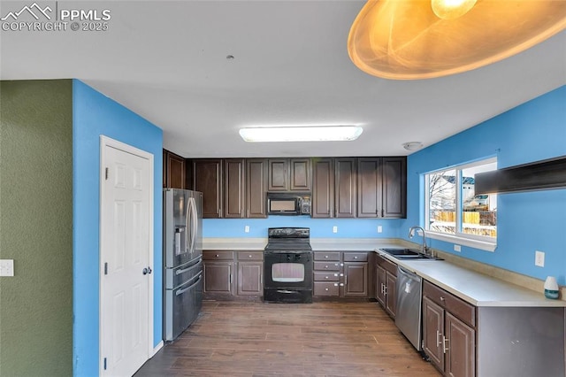 kitchen featuring dark hardwood / wood-style flooring, dark brown cabinetry, sink, and black appliances