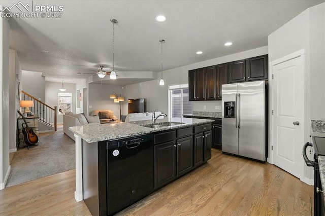 kitchen featuring sink, black dishwasher, stainless steel fridge with ice dispenser, an island with sink, and pendant lighting