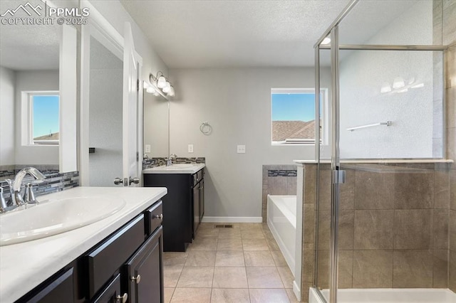 bathroom with tile patterned flooring, a textured ceiling, vanity, and separate shower and tub