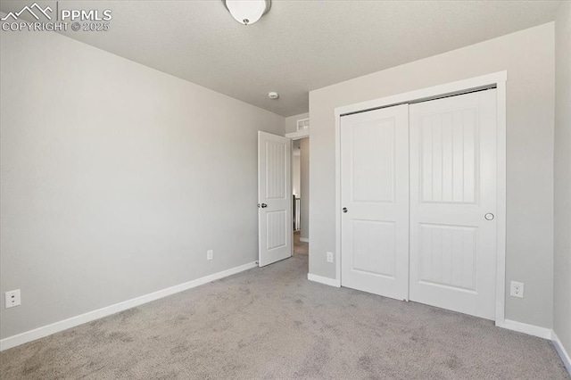 unfurnished bedroom with a closet and light colored carpet