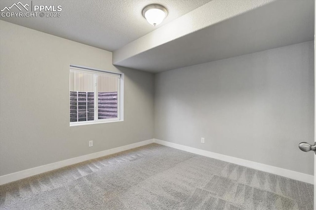 unfurnished room with carpet flooring and a textured ceiling