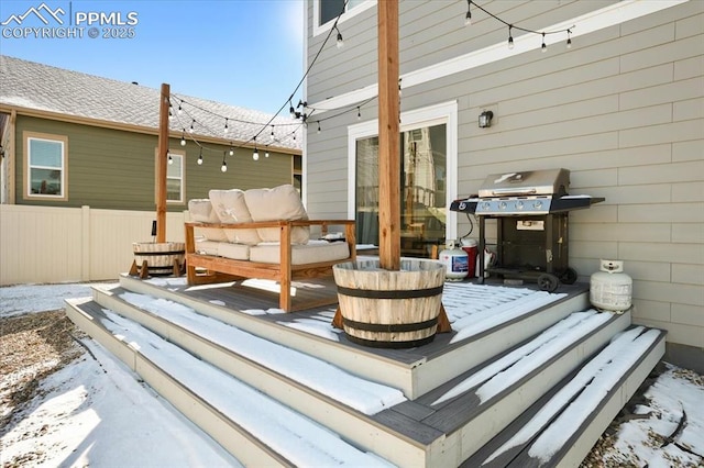 snow covered deck with a grill