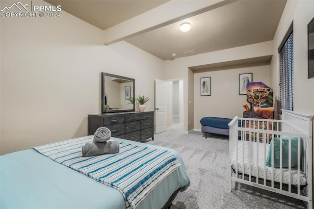 bedroom with beamed ceiling and light colored carpet