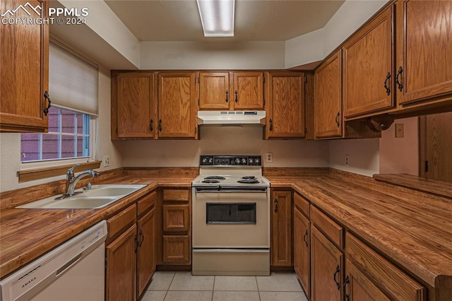 kitchen with white appliances, sink, light tile patterned floors, and wooden counters