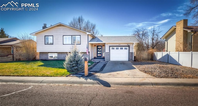 split level home with a front lawn and a garage