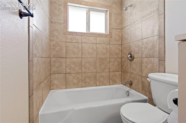 bathroom with tiled shower / bath combo and toilet