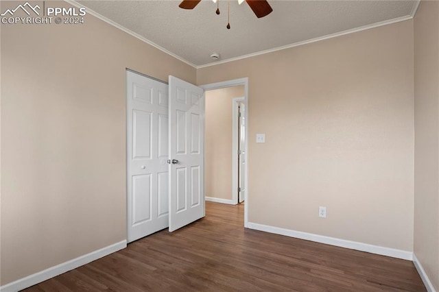 unfurnished bedroom featuring baseboards, dark wood-style flooring, and crown molding