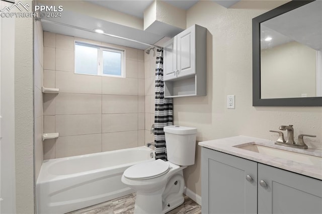 full bathroom featuring hardwood / wood-style floors, vanity, shower / bath combination with curtain, and toilet