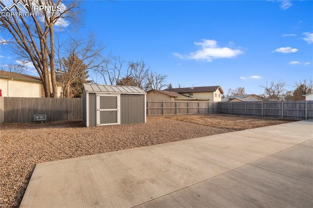 view of yard with an outdoor structure, a storage unit, and a fenced backyard