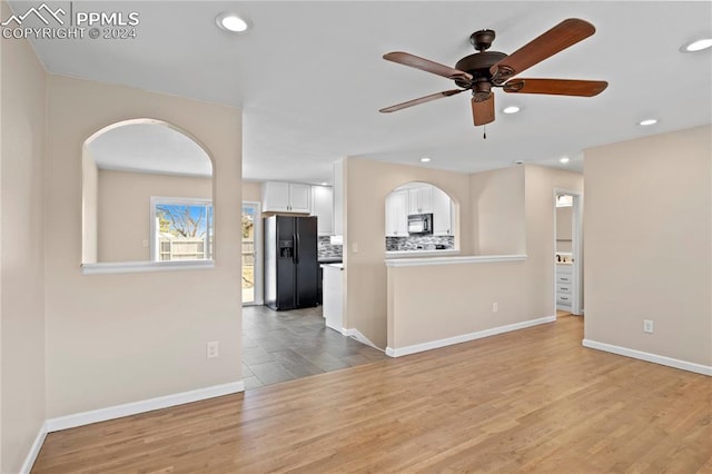 unfurnished living room with ceiling fan and light wood-type flooring