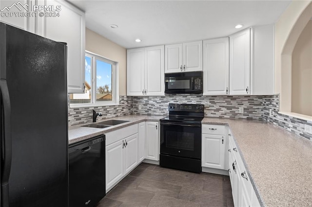 kitchen featuring sink, backsplash, white cabinetry, and black appliances