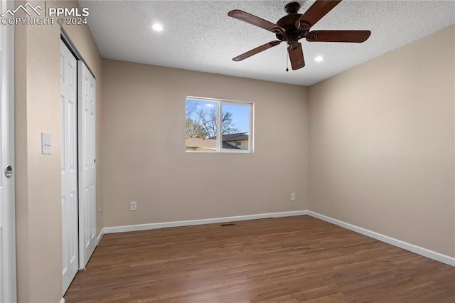 unfurnished bedroom with baseboards, a textured ceiling, and wood finished floors