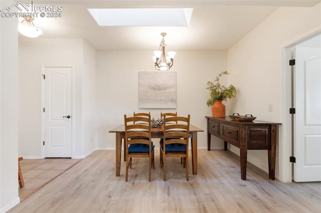 dining space featuring a chandelier, light wood-type flooring, and a skylight