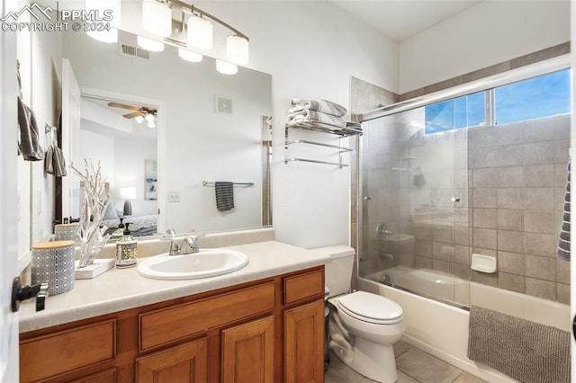 full bathroom featuring vanity, ceiling fan, shower / bath combination with glass door, tile patterned flooring, and toilet