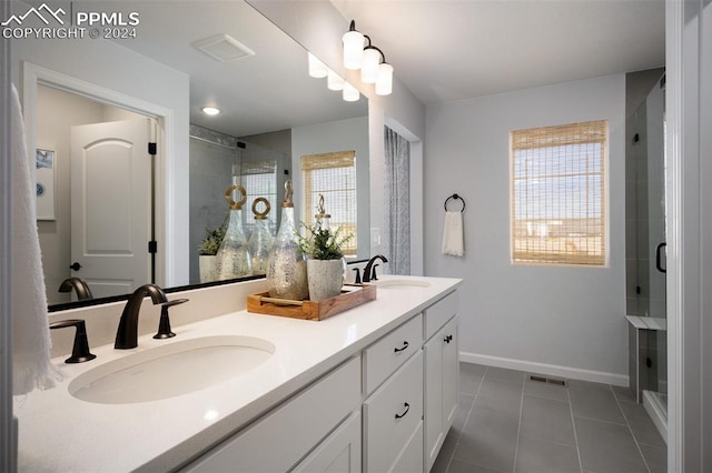 bathroom with tile patterned flooring, vanity, and walk in shower