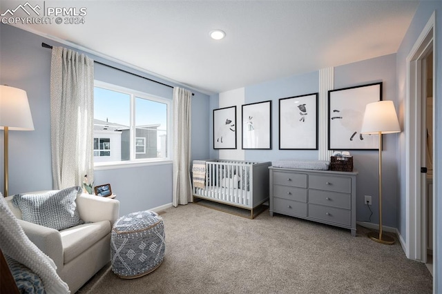 bedroom with light colored carpet and a crib