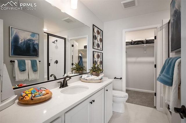 bathroom featuring tile patterned flooring, vanity, toilet, and an enclosed shower