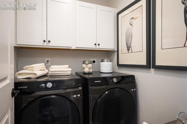 laundry room with cabinets and washing machine and clothes dryer