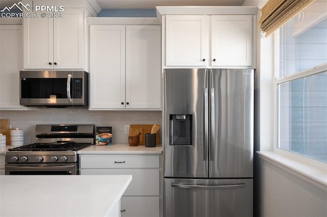 kitchen featuring appliances with stainless steel finishes, tasteful backsplash, and white cabinetry