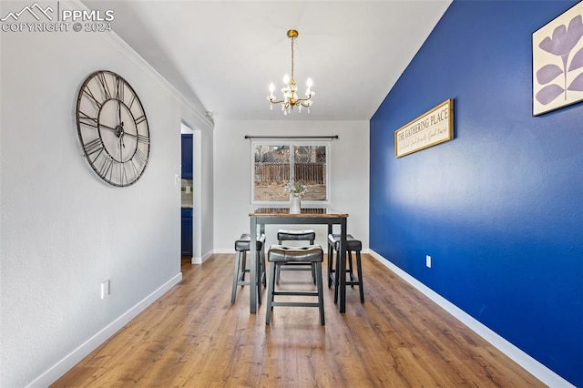 dining area with wood-type flooring and a notable chandelier