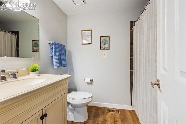 bathroom with wood-type flooring, vanity, and toilet