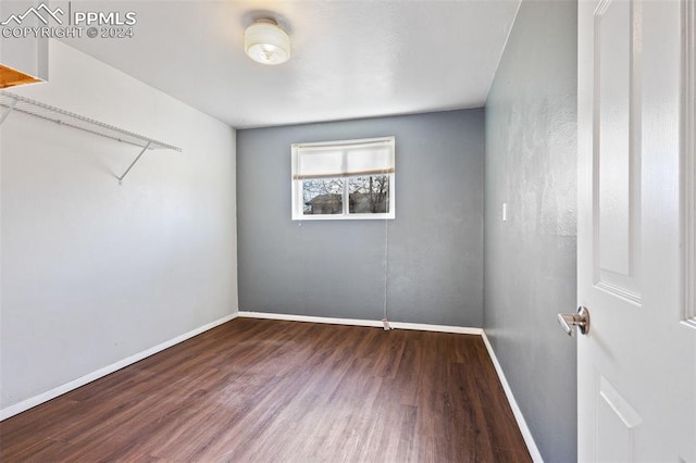 unfurnished room with dark hardwood / wood-style flooring