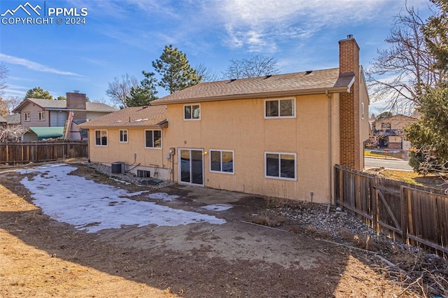 rear view of property with central AC