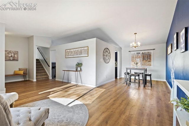 living room with a chandelier, hardwood / wood-style floors, and vaulted ceiling