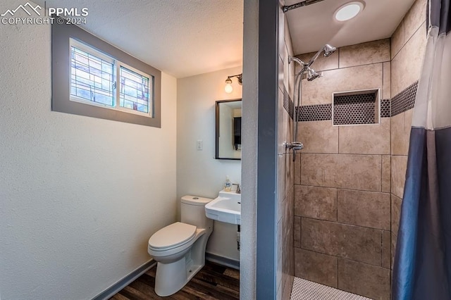 bathroom featuring sink, curtained shower, wood-type flooring, and toilet