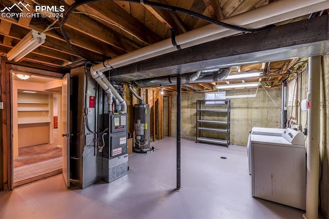 basement featuring heating unit, washing machine and clothes dryer, and water heater