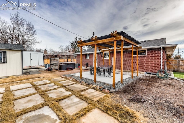 view of patio / terrace featuring a storage unit, a hot tub, and a pergola