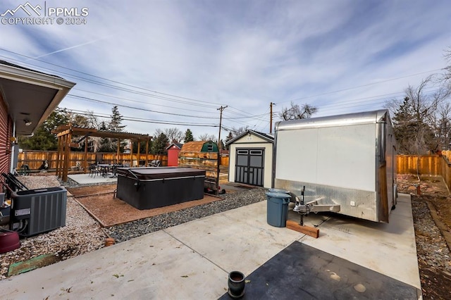 view of patio with cooling unit, a pergola, a hot tub, and a storage unit