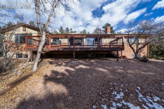 rear view of property featuring a wooden deck