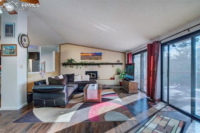 living room with wood-type flooring, a wood stove, and lofted ceiling