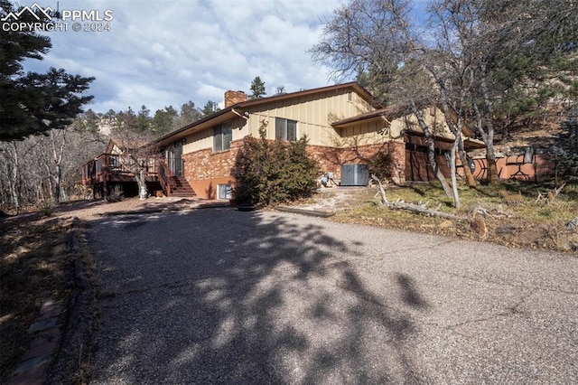 view of property exterior with central air condition unit and a wooden deck