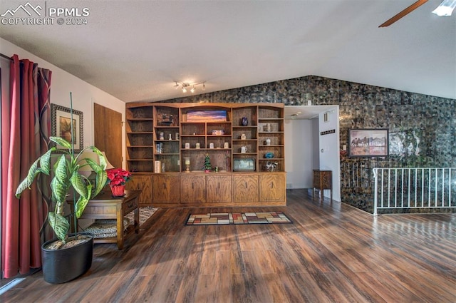 living area featuring ceiling fan, wood-type flooring, and vaulted ceiling