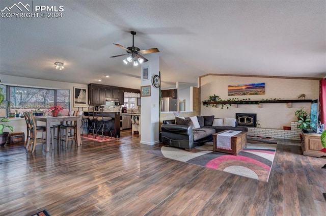 living room with dark hardwood / wood-style floors, ceiling fan, lofted ceiling, and a textured ceiling