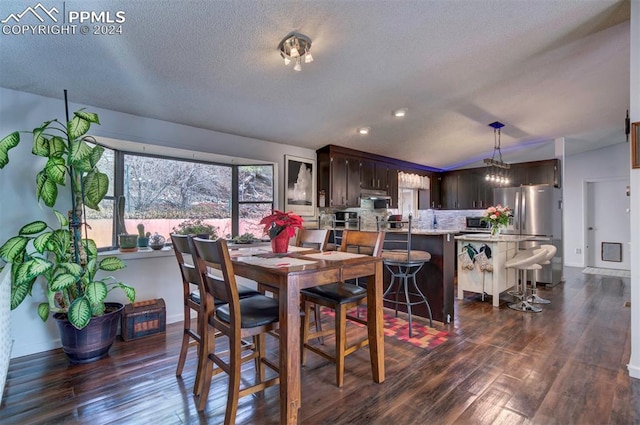 dining room featuring a textured ceiling and dark hardwood / wood-style floors