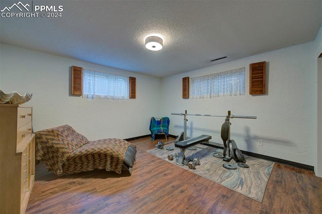 workout area with dark hardwood / wood-style floors and a textured ceiling