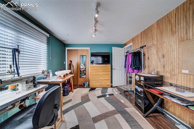 office area with wood walls and a textured ceiling