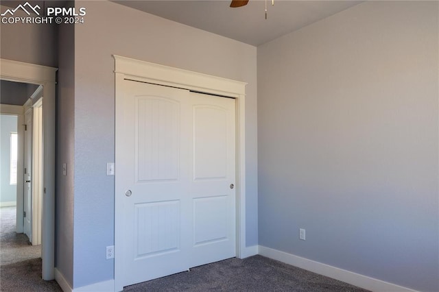 unfurnished bedroom featuring dark colored carpet and ceiling fan