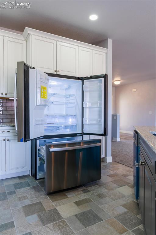 kitchen with tasteful backsplash, dishwasher, and white cabinets