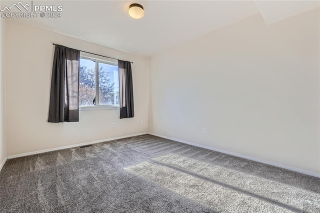 empty room featuring dark colored carpet