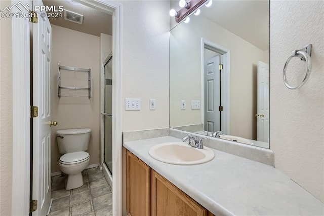 bathroom featuring vanity, toilet, and an enclosed shower