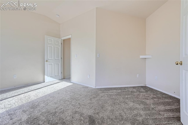 carpeted spare room with lofted ceiling