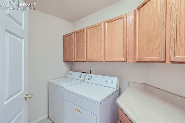 laundry room with washer and dryer and cabinets